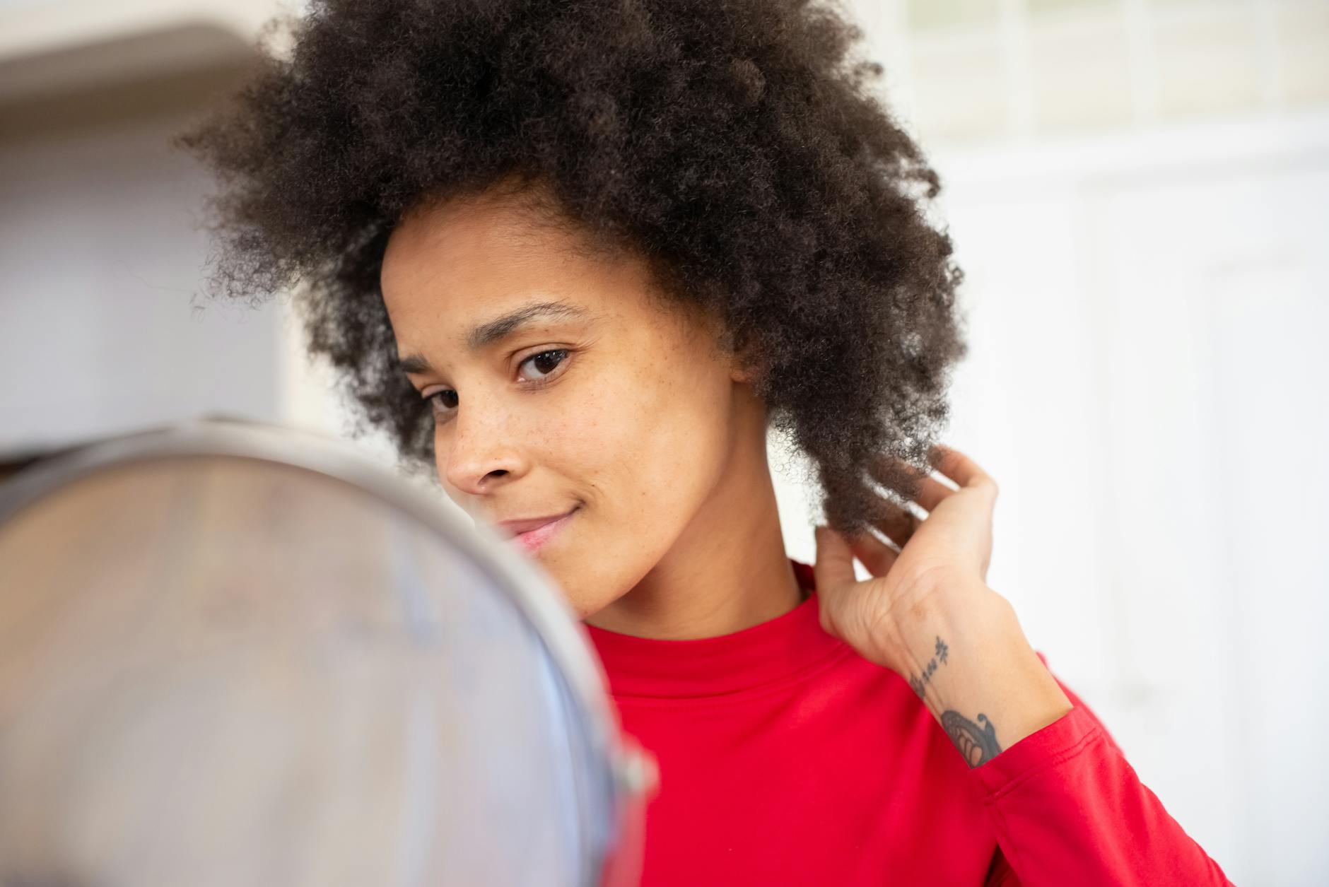 Person looking thoughtfully in mirror with soft natural lighting