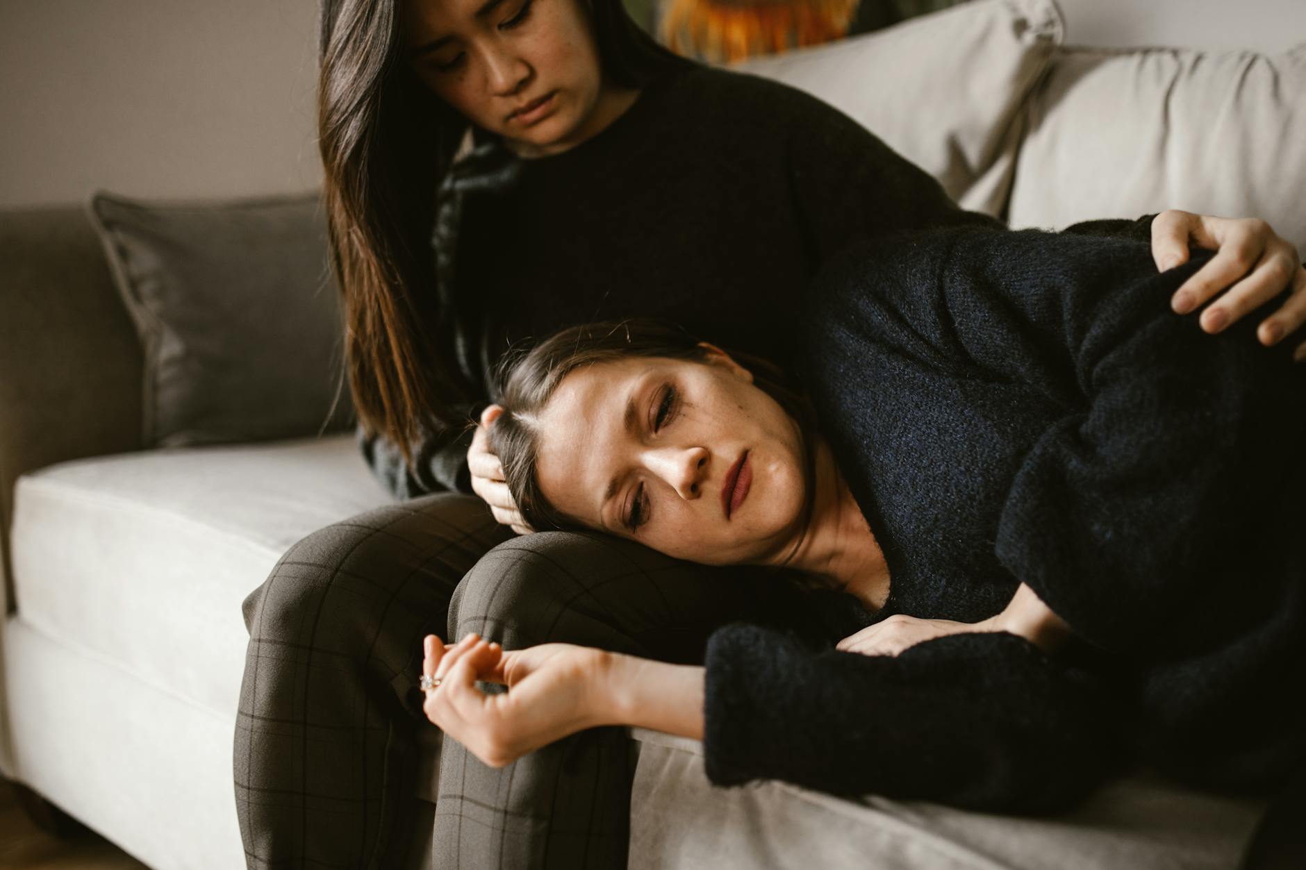 Person sitting peacefully by a window with soft natural light, representing contemplation during grief